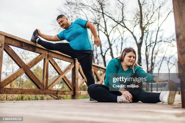 people with overweight problem exercising in city park - obesitas stockfoto's en -beelden