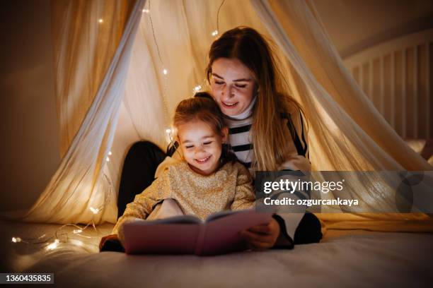 mother and child reading book in bed before going to sleep - kids sleep in bed stockfoto's en -beelden