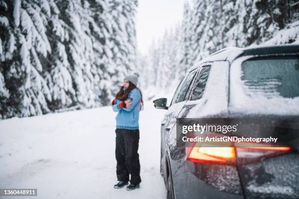 車の故障後に雪の道で援助を待っている女性 - vehicle breakdown ストックフォトと画像