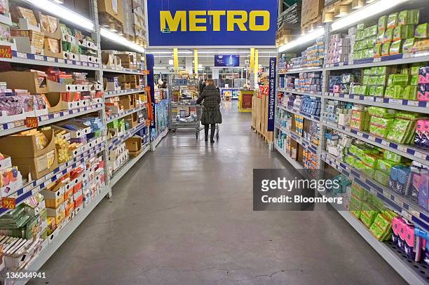 Customer pushes a shopping cart through an aisle at a Metro Cash & Carry store, operated by Metro AG, in Kiev, Ukraine, on Tuesday, Dec. 20, 2011....