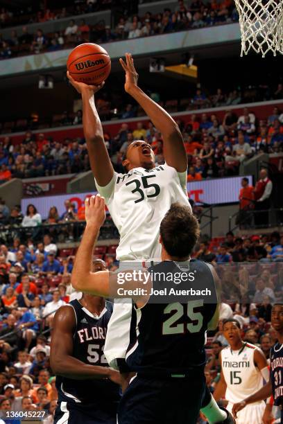 Kenny Kadji of the Miami Hurricanes goes to the basket over Pablo Bertone of the Florida Atlantic Owls at the Orange Bowl Basketball Classic on...