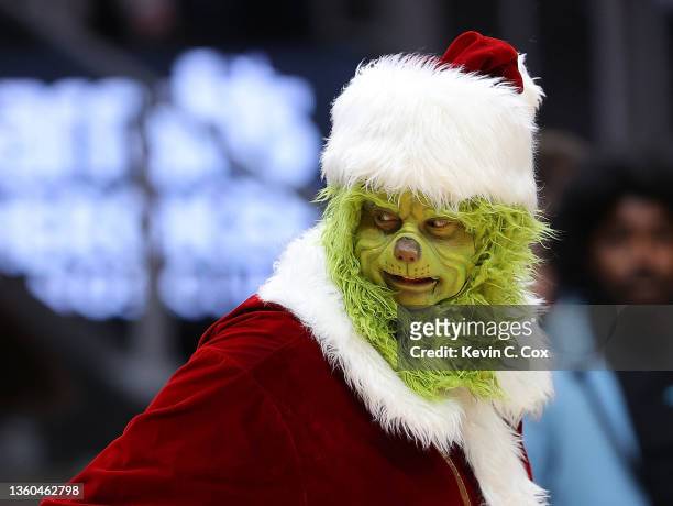 The Grinch character is seen tossing out shirts during the first half between the Atlanta Hawks and the Orlando Magic at State Farm Arena on December...