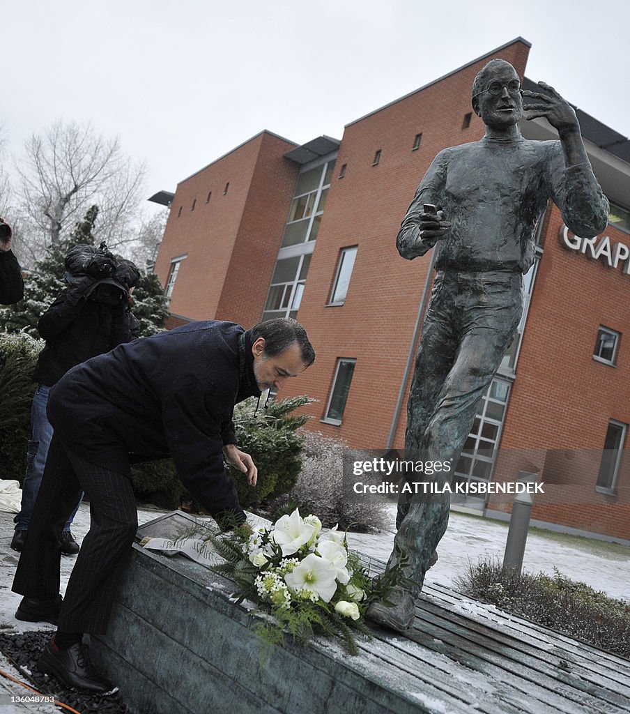 A visitor lays flower at a statue of the