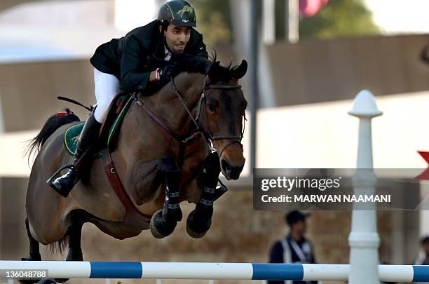 Prince Abdullah al-Saud clears a hurdle on Senorita and takes his team to gold during the equestrian team final, at the Arab Games in Doha, on...