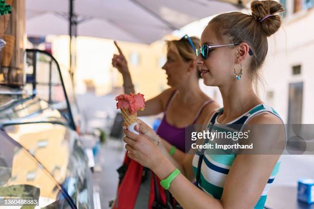 mother and teenage daughter buying italian home made ice cream in a small town - girl who stands stock pictures, royalty-free photos & images