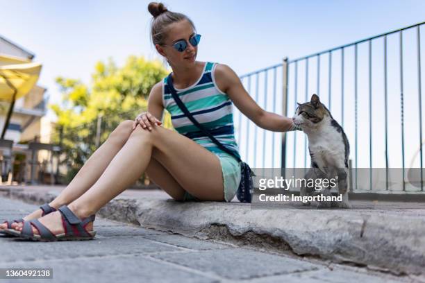 teenage girl petting street cat in the small italian town - cute 15 year old girls stock pictures, royalty-free photos & images
