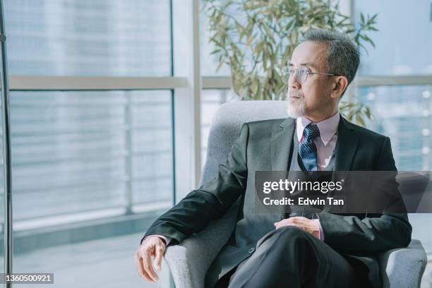 successful asian chinese senior manager looking away sitting at office lounge - only senior men 個照片及圖片檔