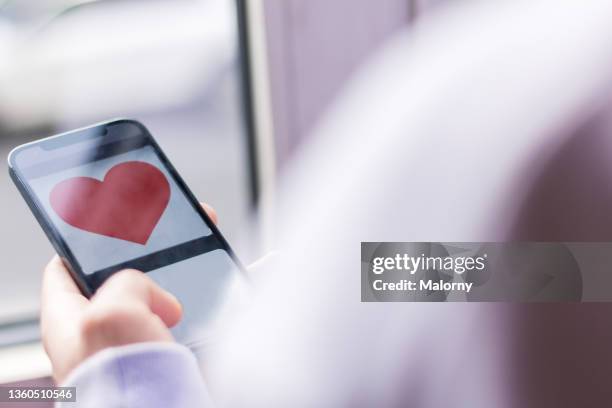 close-up of a young man using an online dating app. - dating app stock pictures, royalty-free photos & images