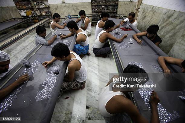 Laborers work at Naaz Embroidery shop October 24, 2009 in Dharavi, India's largest slum, Mumbai, India. The shop produces embroideries for many...