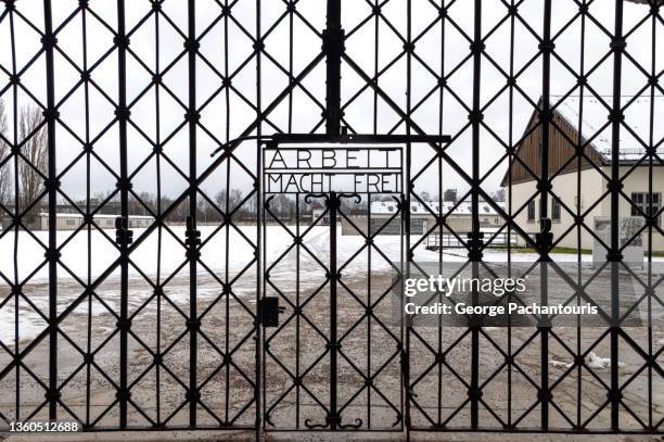 the "arbeit macht frei" sign at the entrance of dachau concentration camp - dachau concentration camp stockfoto's en -beelden