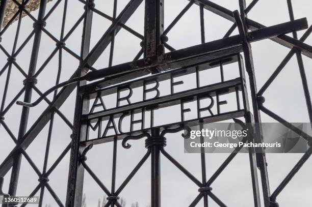 the "arbeit macht frei" sign at the entrance of dachau concentration camp - world war ii germany stock pictures, royalty-free photos & images