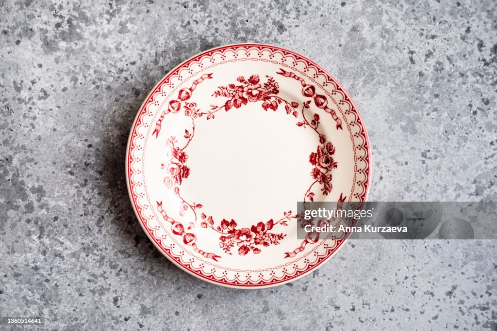 Vintage empty plate on grey concrete background, top view