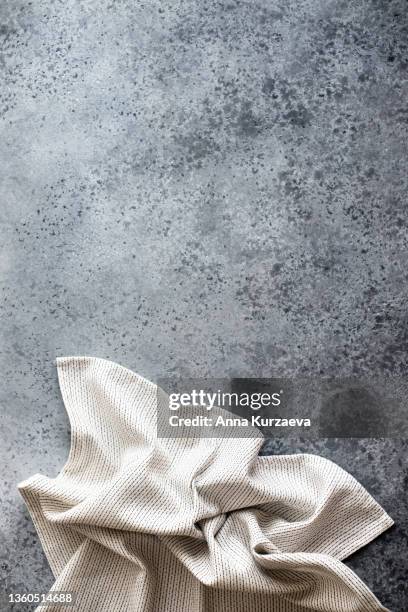 white and black linen striped napkin folded on grey concrete background, top view. copy space - serviette de table stockfoto's en -beelden