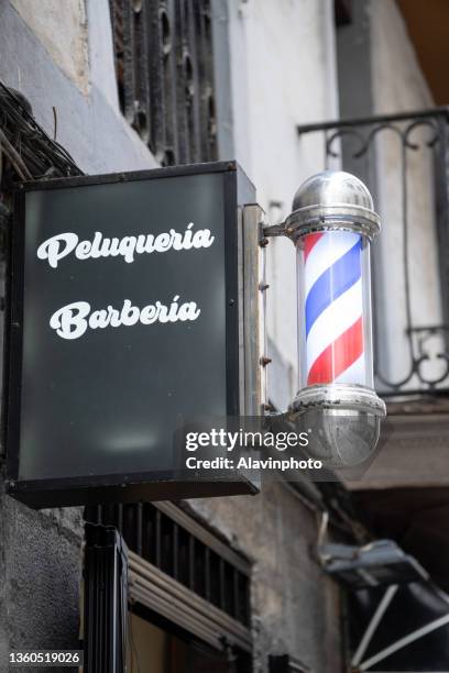 old barber shop poster in spanish - barber pole stock pictures, royalty-free photos & images