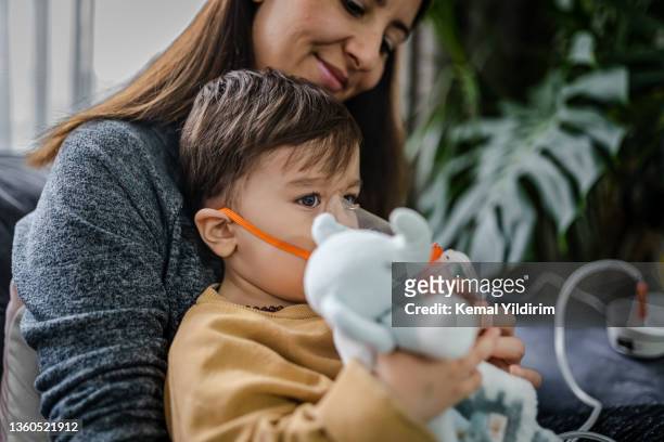 baby boy taking inhalation treatment at home. - childhood asthma stock pictures, royalty-free photos & images
