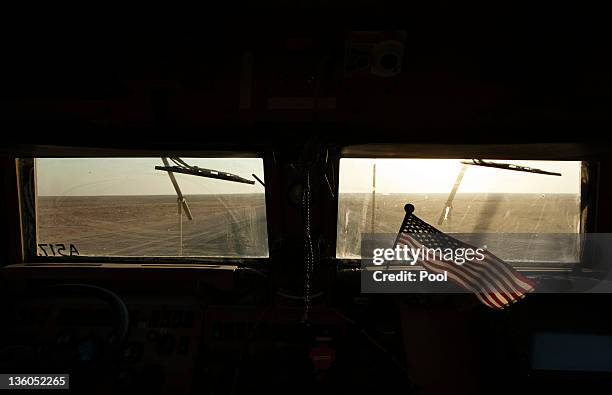 The Kuwaiti desert stretches beyond a U.S. Flag on the dashboard of a Mine Resistant Ambush Protected vehicle from the 3rd Brigade Combat Team, 1st...