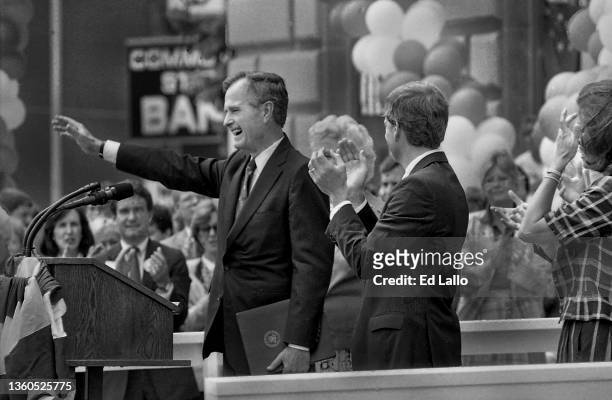 American politician George HW Bush waves from a lectern during a campaign rally, Huntington, Indiana, August 18, 1988. Among those also on the podium...