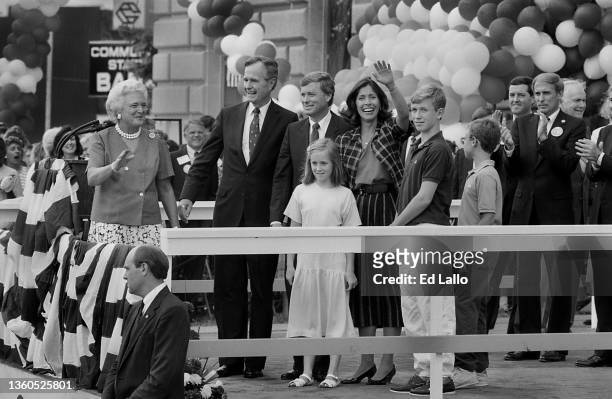 View of married couples Barbara Bush & George HW Bush and Dan Quayle & Marilyn Quayle, along with others, wave from a podium during a campaign rally,...