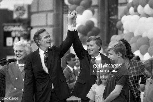 American politician George HW Bush anf Dan Quayle raise their hands on a podium during a campaign rally, Huntington, Indiana, August 18, 1988. Among...