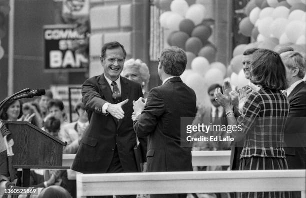 American politician George HW Bush shakes hands with Dan Quayle on a podium during a campaign rally, Huntington, Indiana, August 18, 1988. Among...