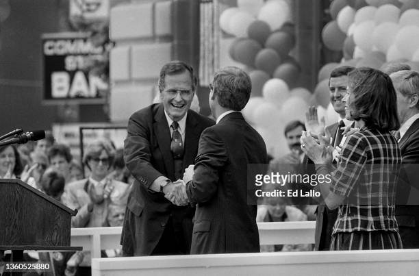 American politician George HW Bush shakes hands with Dan Quayle on a podium during a campaign rally, Huntington, Indiana, August 18, 1988. Among...