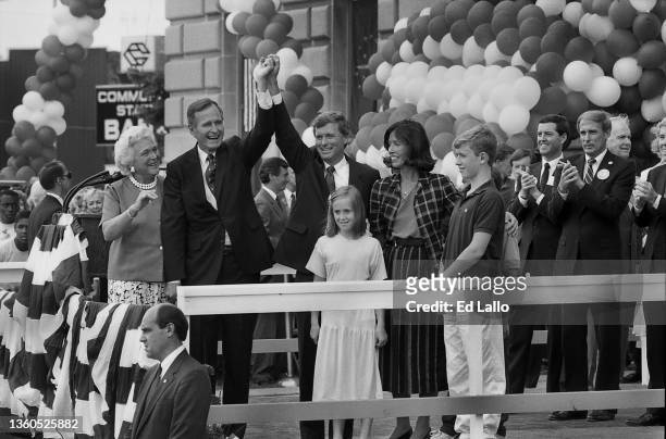 American politician George HW Bush and Dan Quayle raise their hands on a podium during a campaign rally, Huntington, Indiana, August 18, 1988. Among...