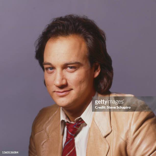 Portrait of American actor Jim Belushi as he poses in a blazer and tie, Los Angeles, California, 1985.