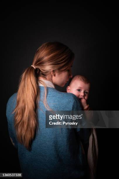 rear view of a mother holding her baby - fine art portrait stockfoto's en -beelden
