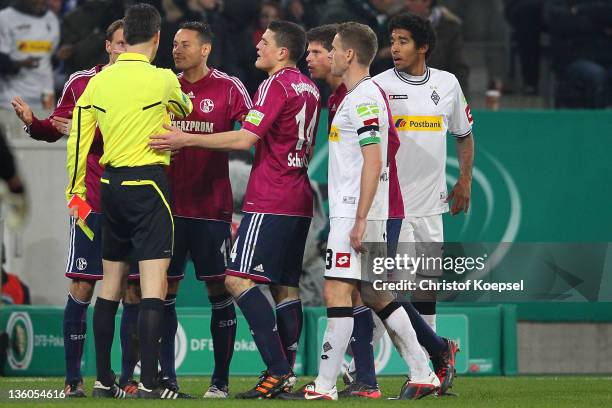 Benedikt Hoewedes , Jermaine Jones , Kyriakos Papadopoulos and Klaas-Jan Huntelaar of Schalke discuss with referee Wolfgang Staerk after sending...