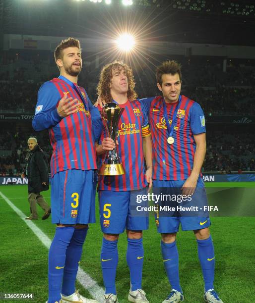 Gerard Pique, Carles Puyol and Cesc Fabregas of Beacelona celebrate victory in the FIFA Club World Cup Final match between Santos and FC Barcelona at...