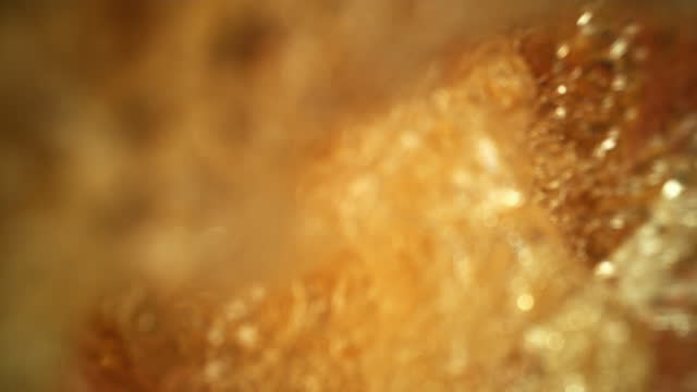 Fresh Beer pouring into Glass as macro super slow motion top shot