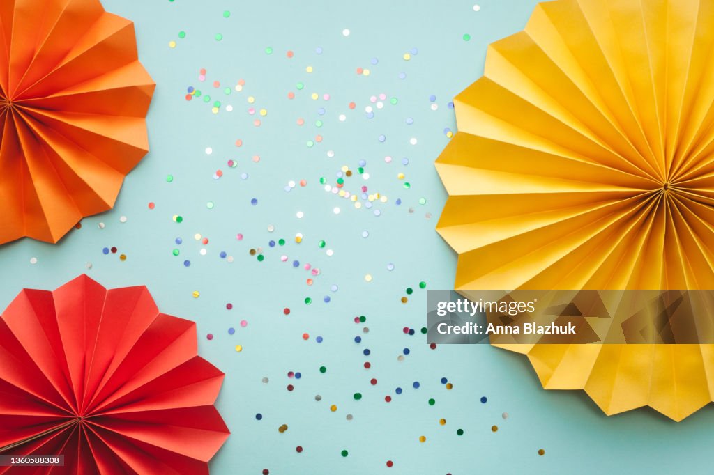 Colorful Party Decorative Paper Fans And Shiny Confetti Over Blue ...