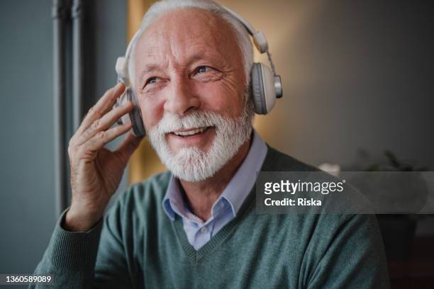close up of senior man with headphones - listening to music old stock pictures, royalty-free photos & images