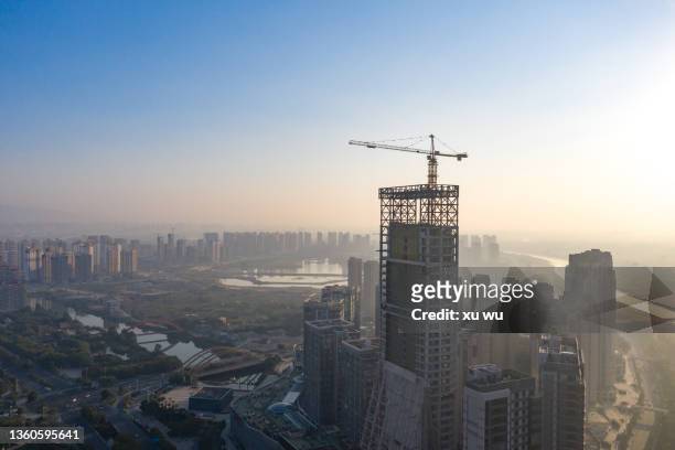 a developing city a high-rise building under construction - construction crane asia stock pictures, royalty-free photos & images