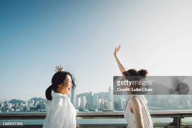 sunny weekend - asian females on a phone imagens e fotografias de stock