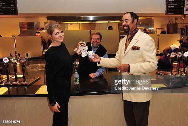 Kate Upton, Drew Nieporent and Walter "Clyde" Frazier try burgers at the new Daily Burger food stand at the New Jersey Nets vs the New York Knicks...
