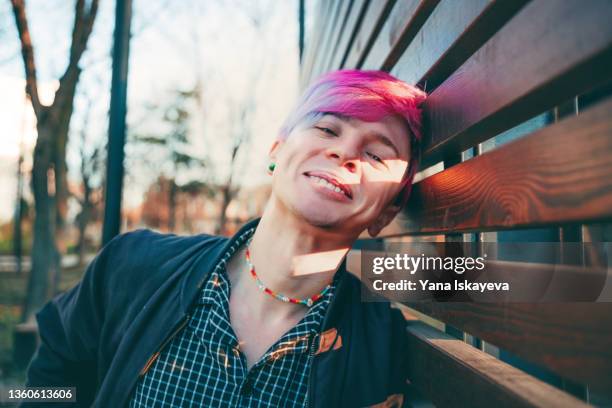 portrait of a young man with colored hair looking at camera and smiling - non binary stereotypes stock pictures, royalty-free photos & images