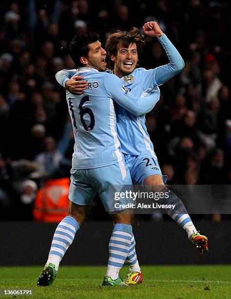 David Silva of Manchester City celebrates scoring the opening goal with team mate Sergio Aguero during the Barclays Premier League match between...
