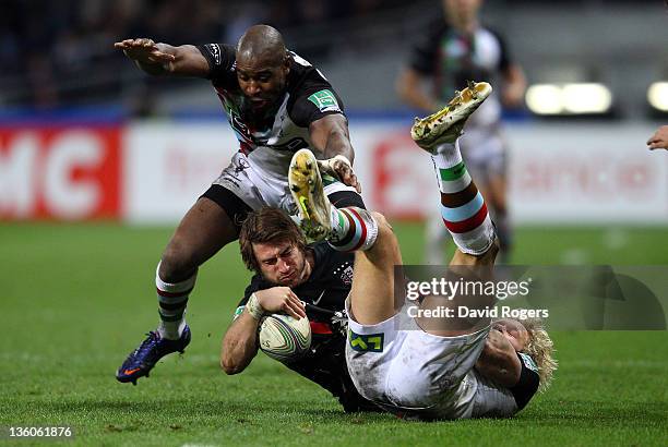 Maxime Medard of Toulouse is tackled by Ugo Monye and Matt Hopper during the Heineken Cup match between Toulouse and Harlequins at Le Stadium on...