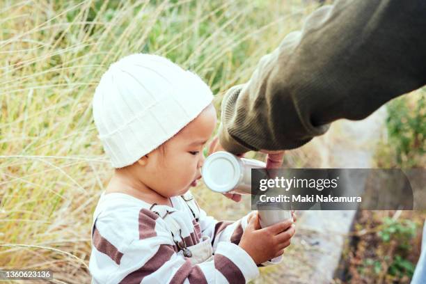 the little boy is drinking water from a water bottle. - water canteen stock pictures, royalty-free photos & images