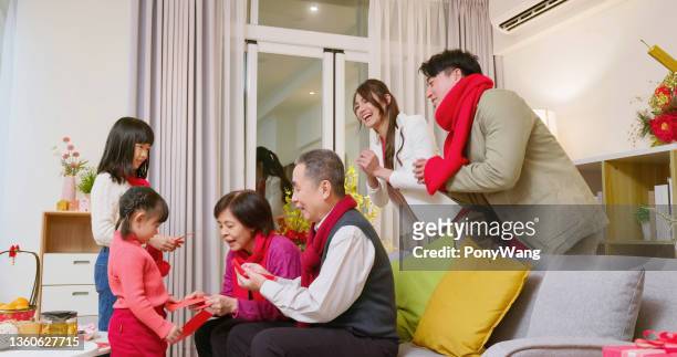 großeltern geben roten umschlag - chinese new year red envelope stock-fotos und bilder