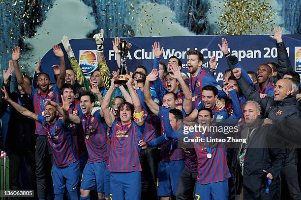 Barcelona captain Carles Puyol lifts the trophy amongst team-mates celebrating after the FIFA Club World Cup Final match between Santosl and...