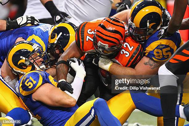 Justin Bannan and Brady Poppinga both of the St. Louis Rams tackle Cedric Benson of the Cincinnati Bengals at the Edward Jones Dome on December 18,...