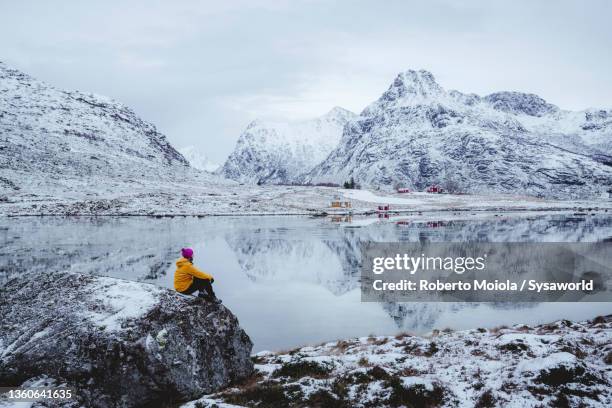 man admiring mountains from frozen fjord in winter, norway - lofoten en vesterålen stockfoto's en -beelden