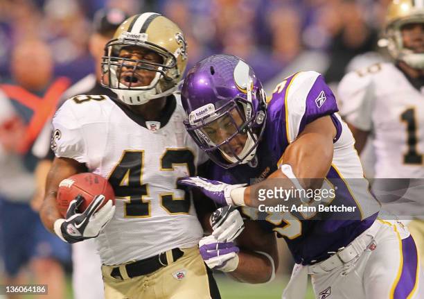 Darren Sproles of the New Orleans Saints carries the ball for a gain while Jamarca Sanford of the Minnesota Vikings pushes him out of bounds at the...