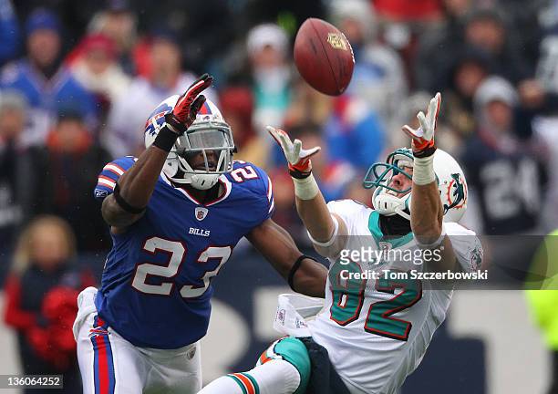Brian Hartline of the Miami Dolphins catches a pass during their NFL game as Aaron Williams of the Buffalo Bills defends at Ralph Wilson Stadium on...