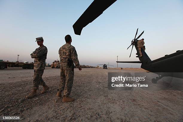 Army National Guard soldiers prepare to depart in a Medevac helicopter to assist the last convoy from Iraq at Camp Adder, now known as Imam Ali Base,...