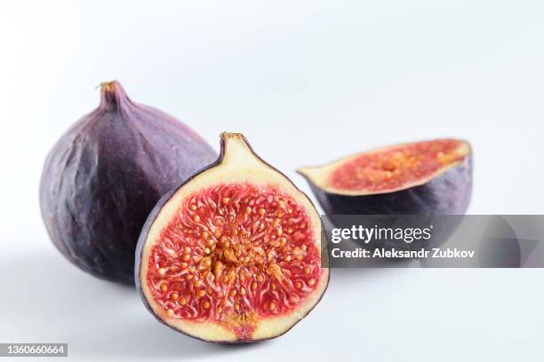 fresh whole and chopped purple figs on a white wooden table. food background. the concept of vegetarian, vegan and raw food. - fig fotografías e imágenes de stock