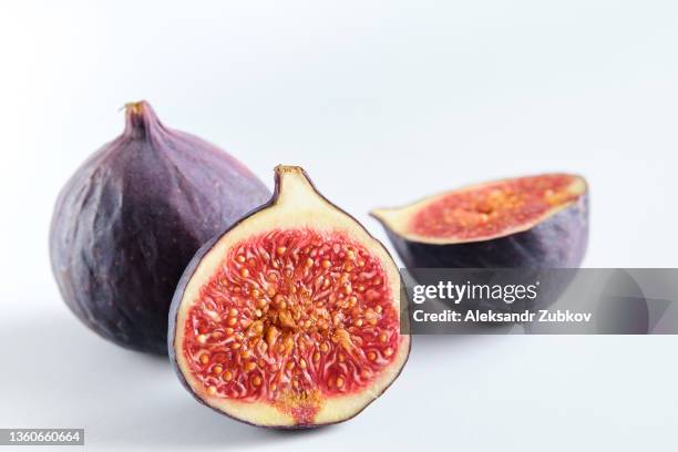 fresh whole and chopped purple figs on a white wooden table. food background. the concept of vegetarian, vegan and raw food. - vijg stockfoto's en -beelden