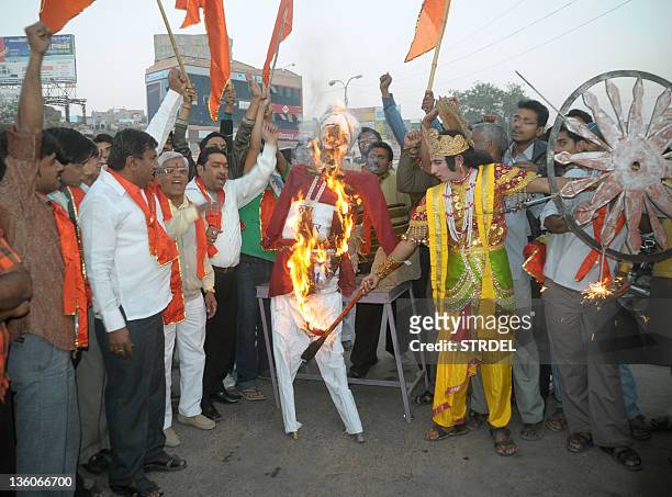 Man dressed as Hindu Lord Krishna burns an effigy symbolising the Russian government during a protest by members of hardline Hindu organisation...
